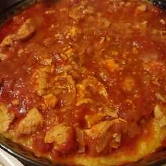 A picture of Polenta con queso y estofado de pollo.