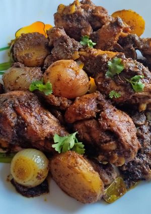 A picture of Pepper chicken legs roast with mushroom and potatoes.