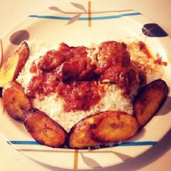A picture of Fried plantain with white rice and stew.