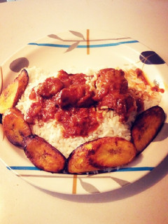 A picture of Fried plantain with white rice and stew.