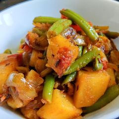 A picture of Stir Fry beans, potatoes and tomatoes in caramelized onions.