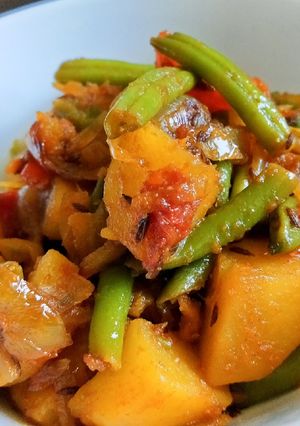 A picture of Stir Fry beans, potatoes and tomatoes in caramelized onions.