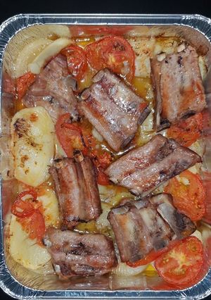 Una foto de Costillas al horno con patatas, tomate y cebolla