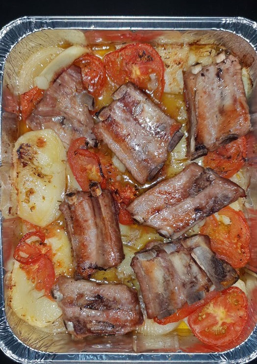 Una foto de Costillas al horno con patatas, tomate y cebolla