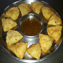 A picture of Samosa with mithhi chutney.