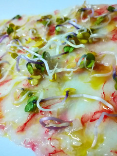 Una foto de Carpaccio de gambas rojas con brotes de raíz de rábano