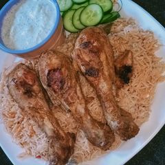 A picture of Chicken drumsticks with tarka rice.