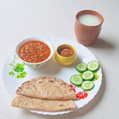 A picture of Kathiyavadi lunch :Fresh lobiya Curry, Roti, Cucumber Slices, Pickle & buttermilk.
