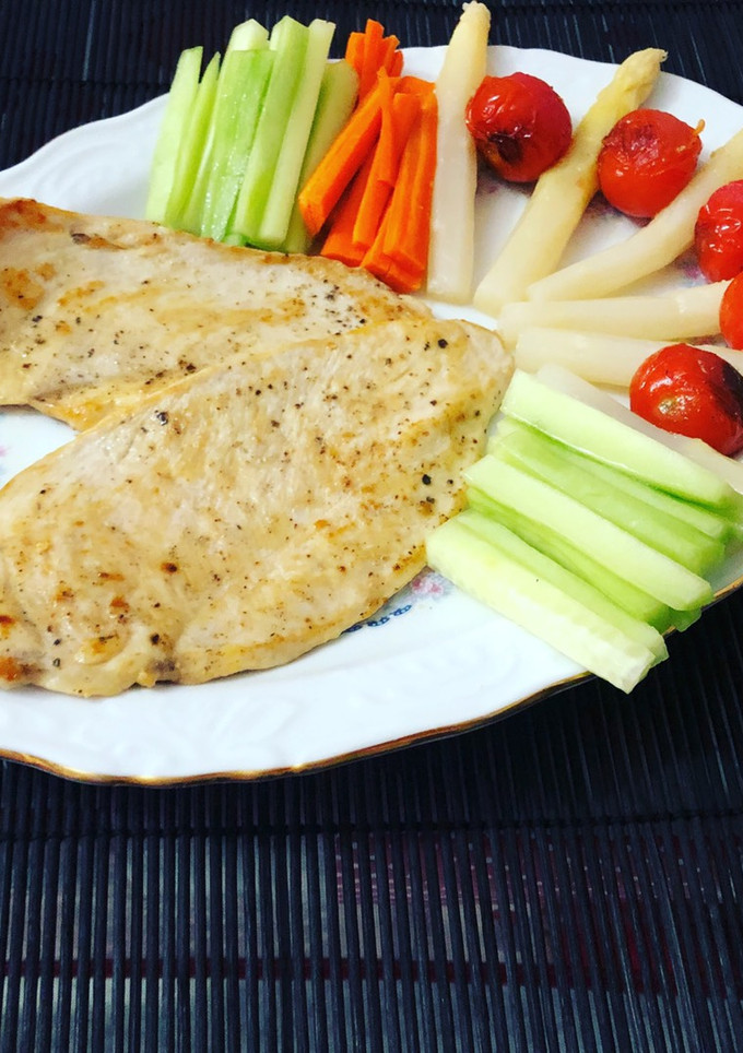 Una foto de Pechuga de pollo a la plancha con guarnición de cherry, pepino, zanahoria y espárrago blanco