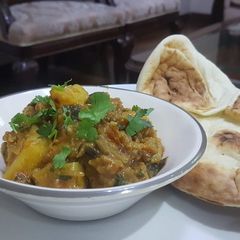 A picture of Aaloo Bangan ki Sabzi with tandoori roti.