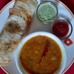 A picture of Dosa with Sambhar and coconut chutney.
