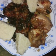 A picture of Cassava ugali with green vegetables and chicken.