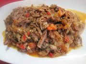 Una foto de carne con jitomate y cebolla