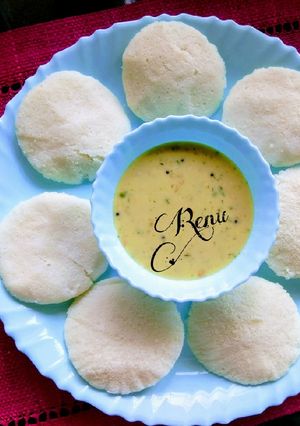 A picture of Idli with coconut Chutni.