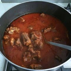 A picture of Tomato stew with assorted meat.