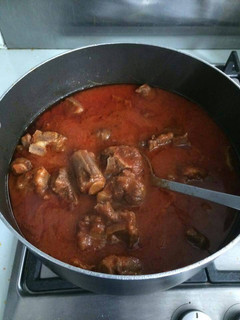 A picture of Tomato stew with assorted meat.