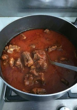 A picture of Tomato stew with assorted meat.