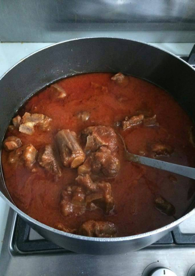 A picture of Tomato stew with assorted meat.