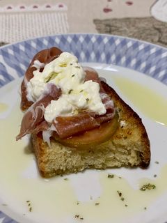 A picture of Bruschetta with Prosciutto and Stracciatella.