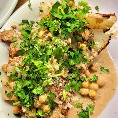 A picture of Whole roasted cauliflowers with peanut butter curry sauce.