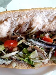 Una foto de Bocadillo de boquerones en vinagre con lechuga, cebolla y tomate