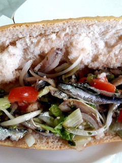 Una foto de Bocadillo de boquerones en vinagre con lechuga, cebolla y tomate