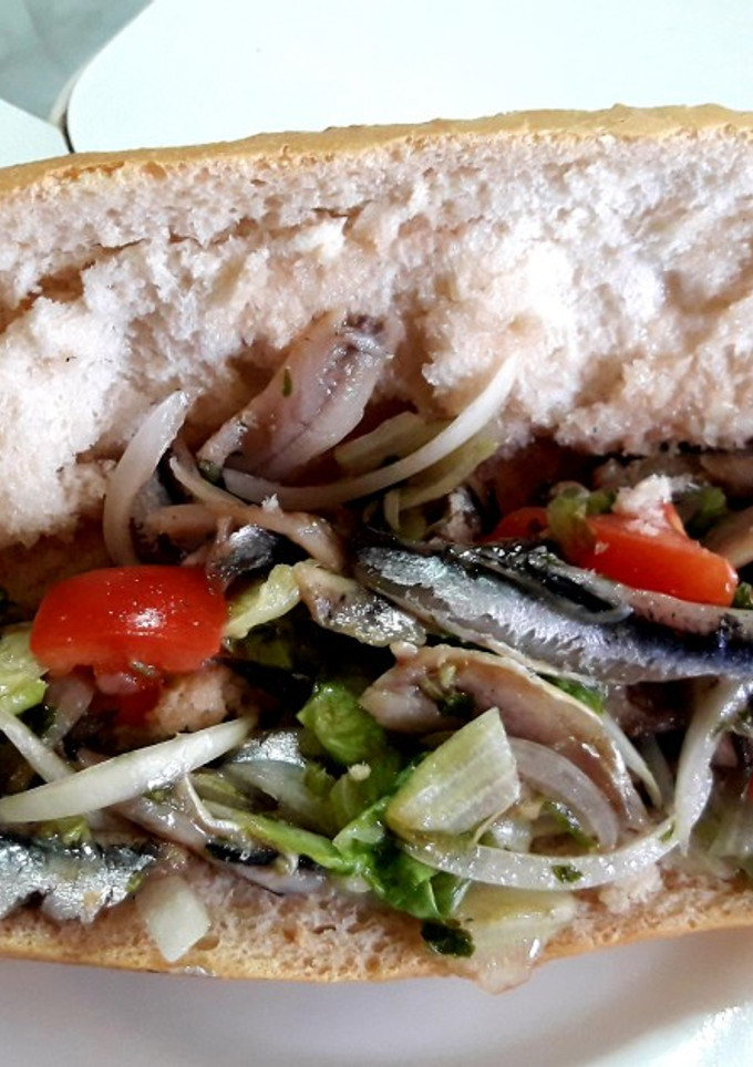 Una foto de Bocadillo de boquerones en vinagre con lechuga, cebolla y tomate