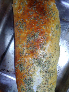 Una foto de Pan casero relleno de jamón y mozzarella, cubierto de orégano