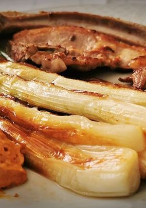 Una foto de Calçots a la plancha con guarnición de carne