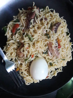 A picture of Noddles with egg,smoked fish and scent leaves.