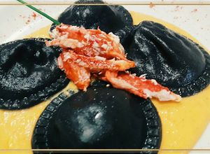 Una foto de Sorrentinos de centolla & salsa de calabaza con tinta de calamar