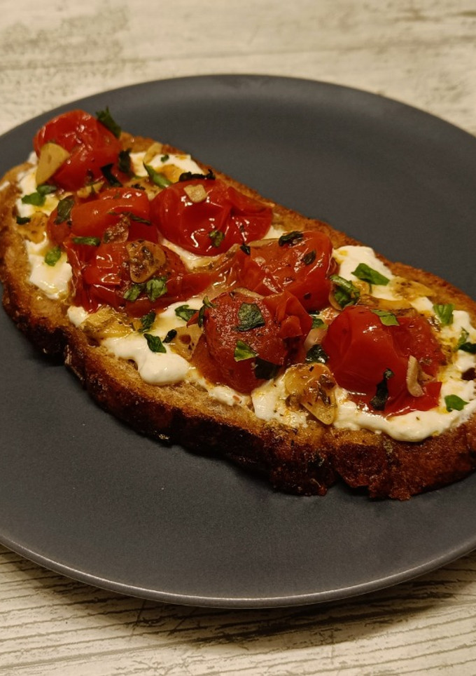 Una foto de Tostada de tomates cherry confitados y burrata