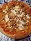 Pizza de cebolla caramelizada, rulo de cabra y pollo