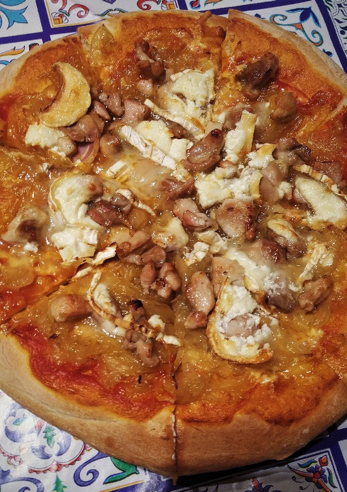 Una foto de Pizza de cebolla caramelizada, rulo de cabra y pollo