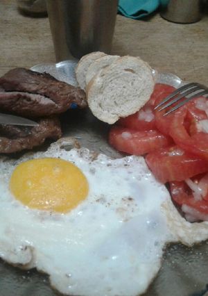 Una foto de Bifes a la plancheta con huevos fritos y ensalada de tomate
