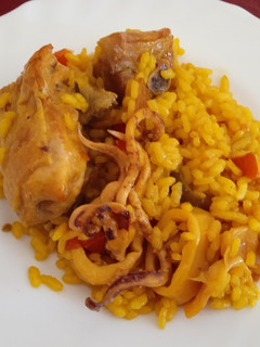 Una foto de Paella de pollo y calamares