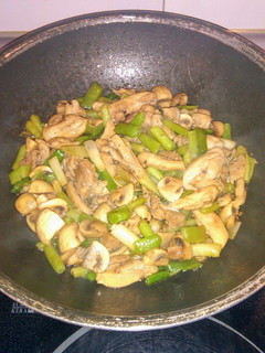 Una foto de Wok de pollo con champiñones y ajetes tiernos