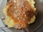 Una foto de polenta con queso con salsa