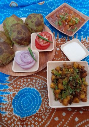 A picture of Palak puri, tariwale aloo, kasuri methi sukha aloo, salad & curd.