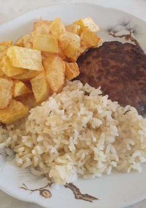 Una foto de Arroz al ajillo, hamburguesa y papas fritas en cubos de Rommy