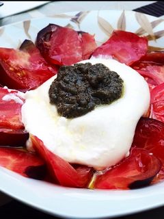 Una foto de Ensalada de burrata, tomate azul y salsa de trufa