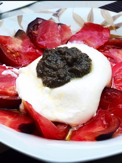 Una foto de Ensalada de burrata, tomate azul y salsa de trufa