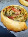 Girelle di sfoglia con pesto al basilico, parmigiani reggiano e pomodorini