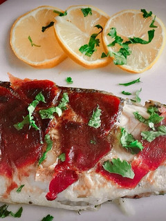 Una foto de Lubina en papillote a la sartén con hierbas aromáticas y jamón
