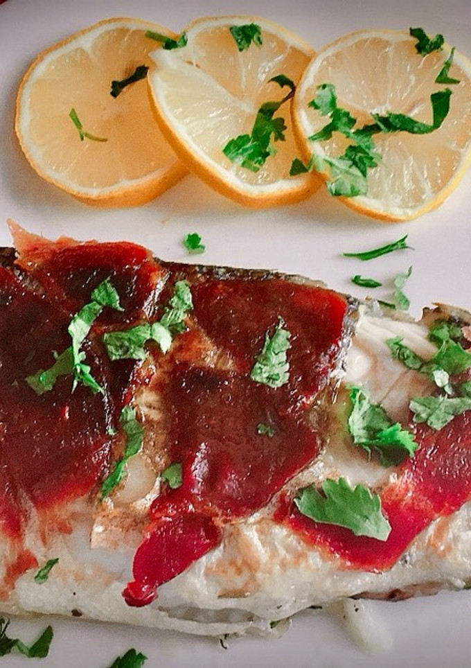 Una foto de Lubina en papillote a la sartén con hierbas aromáticas y jamón