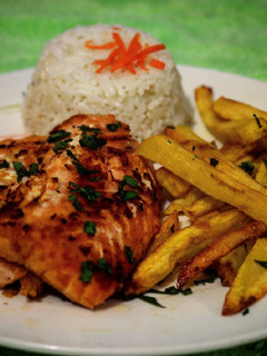 Una foto de Salmón a la mantequilla acompañado de papas fritas y arroz