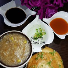 A picture of Chicken Oats soup with spiral garlic bun.