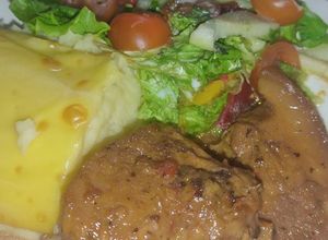 Una foto de Cerdo en salsa de naranja puré gratinado ensalada primavera
