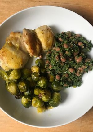 A picture of Roasted chicken thighs and veg with spinach and beans.