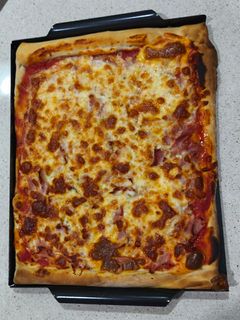 Una foto de Pizza prosciutto con bordes rellenos de cheddar (masa en Thermomix)